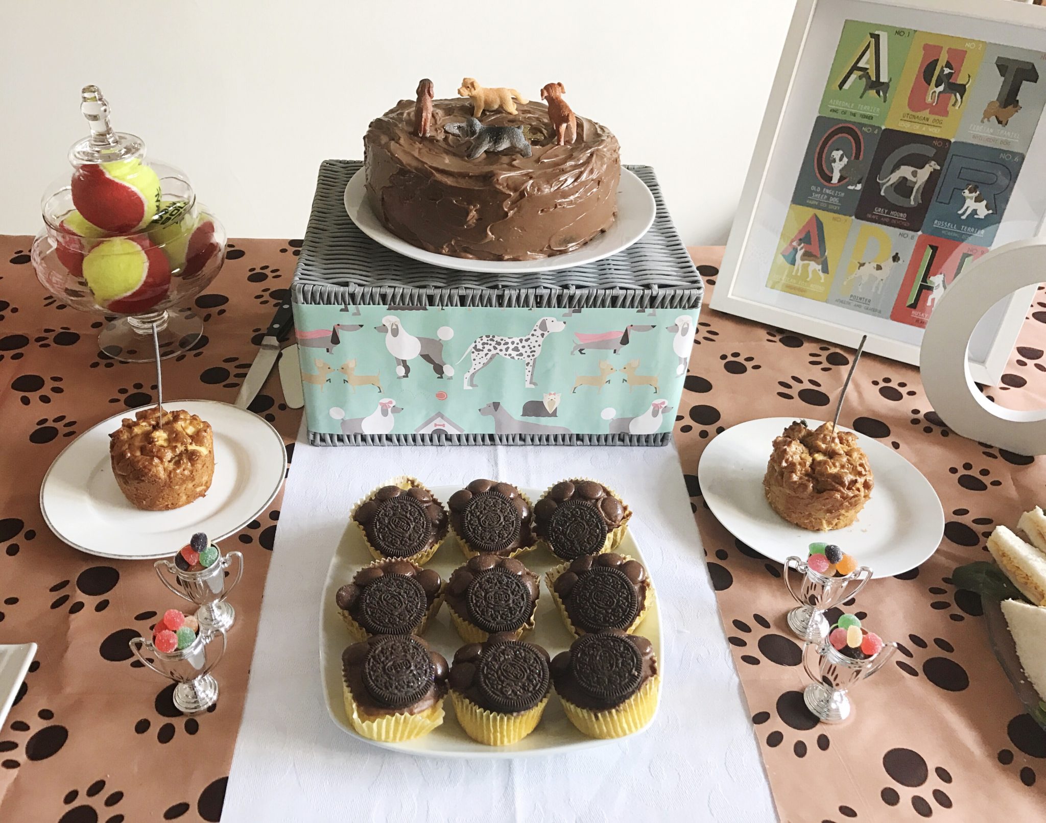 Treat table for a puppy party with birthday cake a and paw print cupcakes