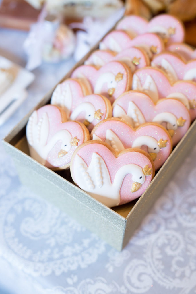 Pink swan biscuits with golden crwons for a baby's swan theme welcome to the world party