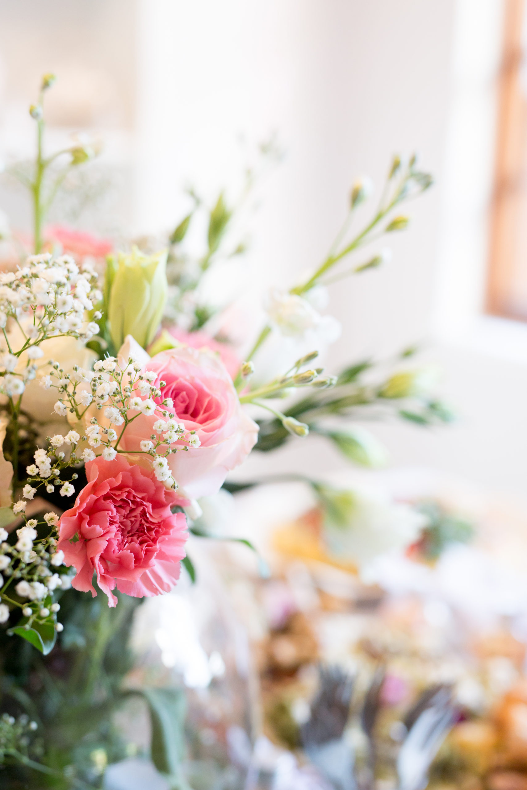 A pretty pink and white floral arrangement as the table centre piece