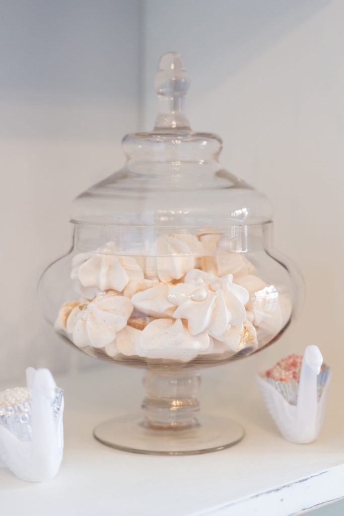 Meringues with sprinkles in glass jars as part of the candy buffet for a swan welcome to the world party