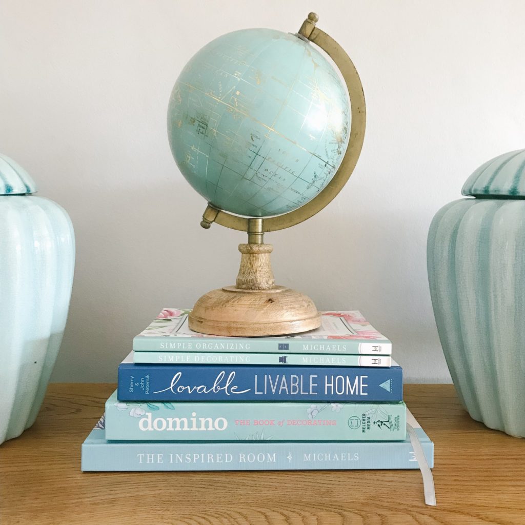 Globe on top of blue home decor coffee table books