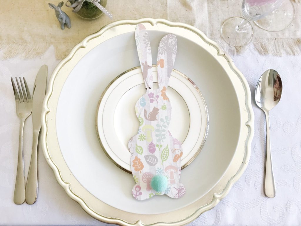 Bunny place settings cut out from scrapbook paper with pom-pom tails