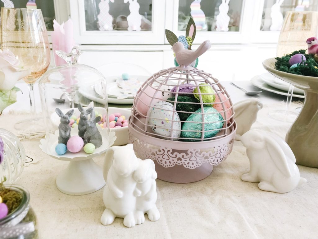 Pastel Easter table decor, pink birdcage filled with Easter eggs
