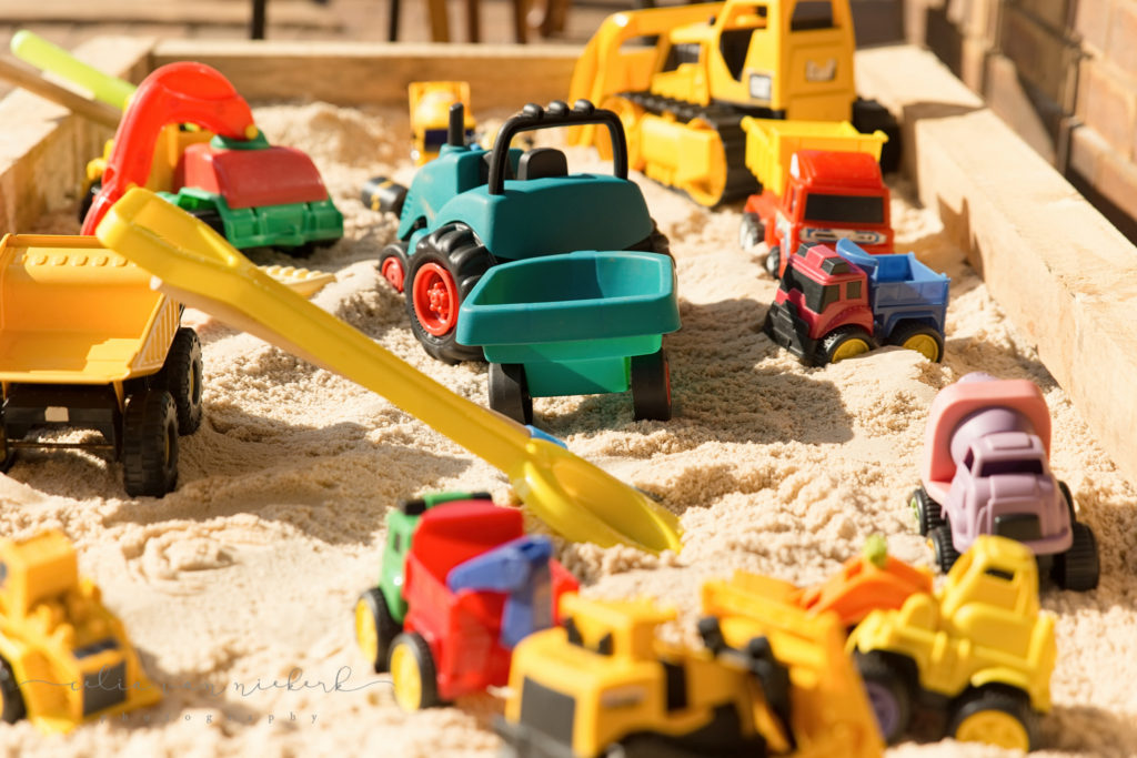 Trucks and spades full of fun in the sandpit for a construction party