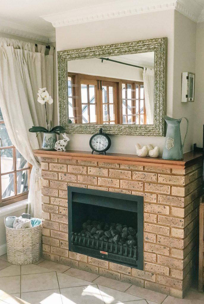 Living room with gold ornate mirror above the fire place