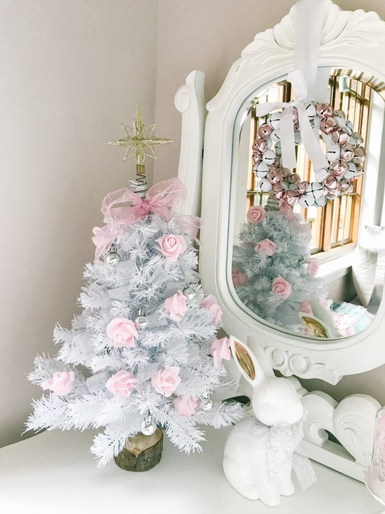 A miniature Christmas tree decorated with pink rose fairy lights